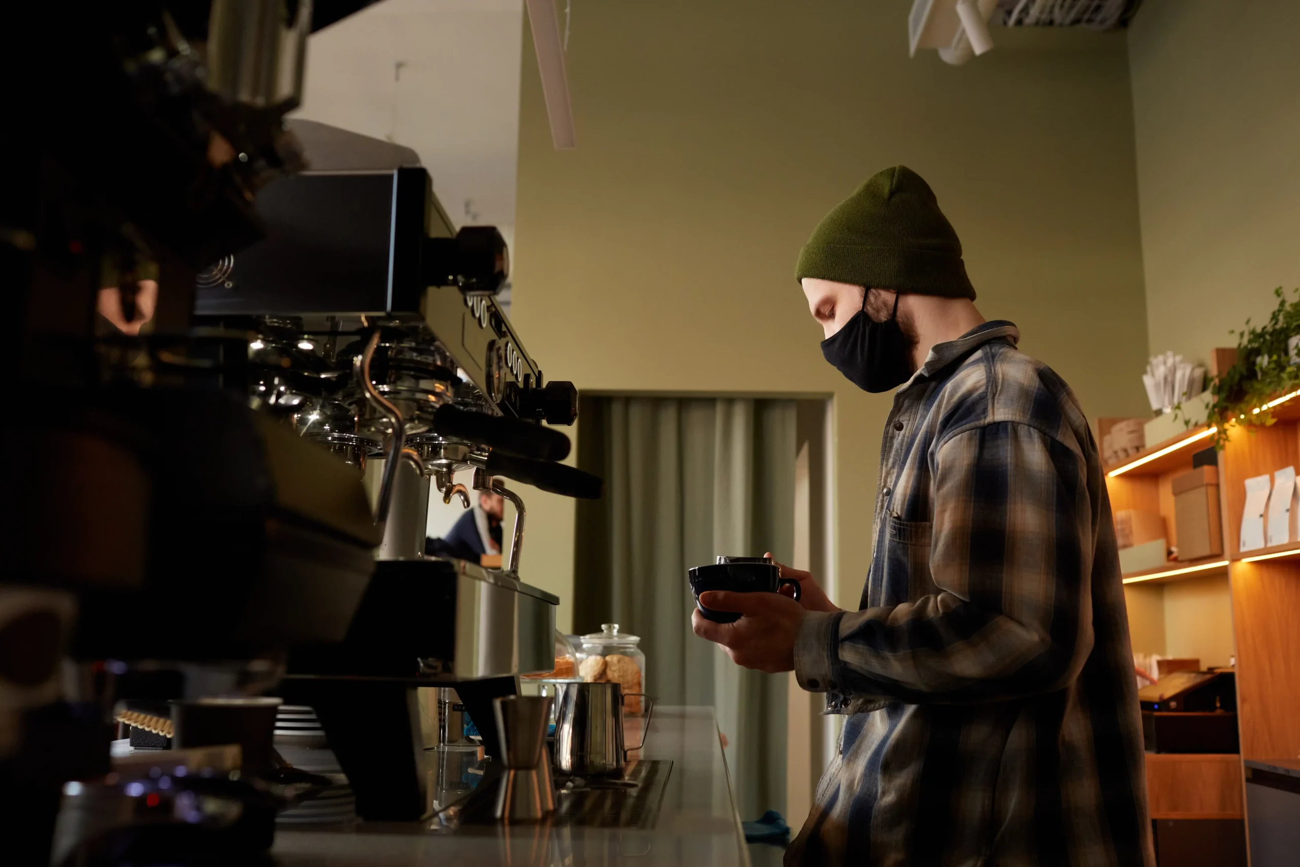 Barista preparing fresh coffee behind the counter of a cafe